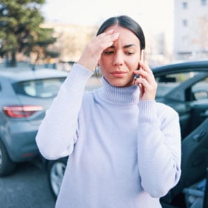 Woman looking stressed while talking on the phone.- The Law Man Group, APC